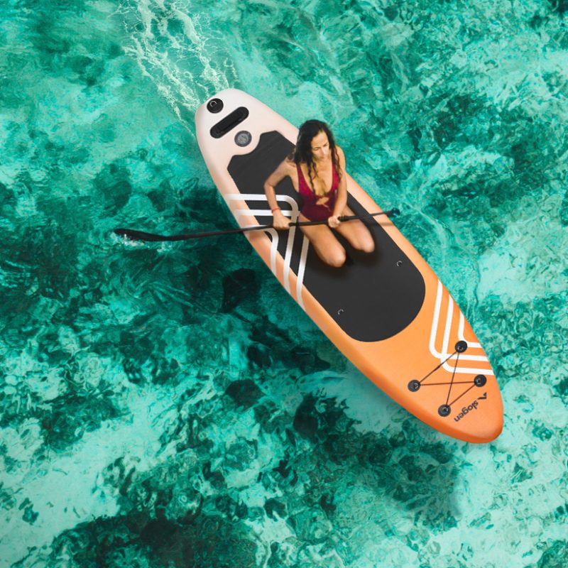Woman sitting on sup board and enjoying turquoise transparent water and coral reef. Tropical travel, wanderlust and water activity concept.